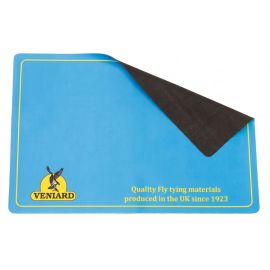 Rechteckige hellblaue Veniard Fly Tyers Mat im A3-Format aus Neopren mit gelbem Rahmen, Veniard-Logo unten links und dem Schriftzug 'Quality Fly tying materials produced in the UK since 1923' unten rechts; eine Ecke ist leicht angehoben und zeigt die schw